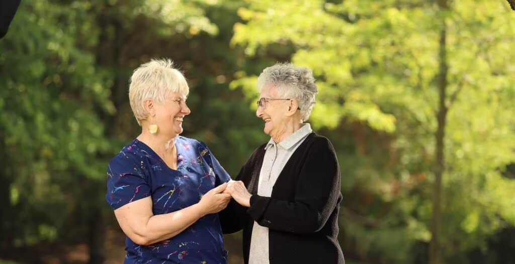 Two female at Monmouth Crossing holding hand and smiling