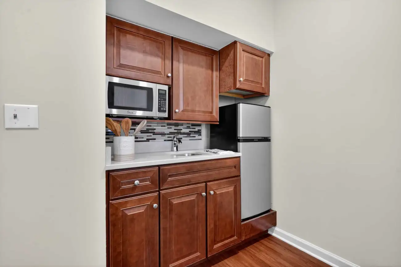 a kitchenette with a microwave and a fridge