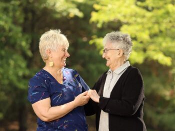 Two female at Monmouth Crossing holding hand and smiling