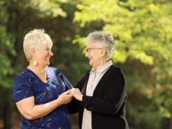 Two female at Monmouth Crossing holding hand and smiling